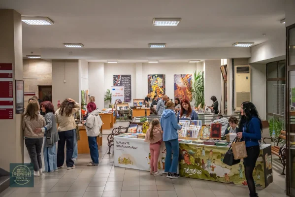 Посетители и деца сред книжните щандове във фоайето на библиотеката.