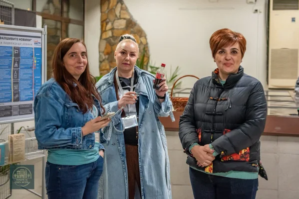 Три жени позират за обща снимка във фоайето на библиотеката.
